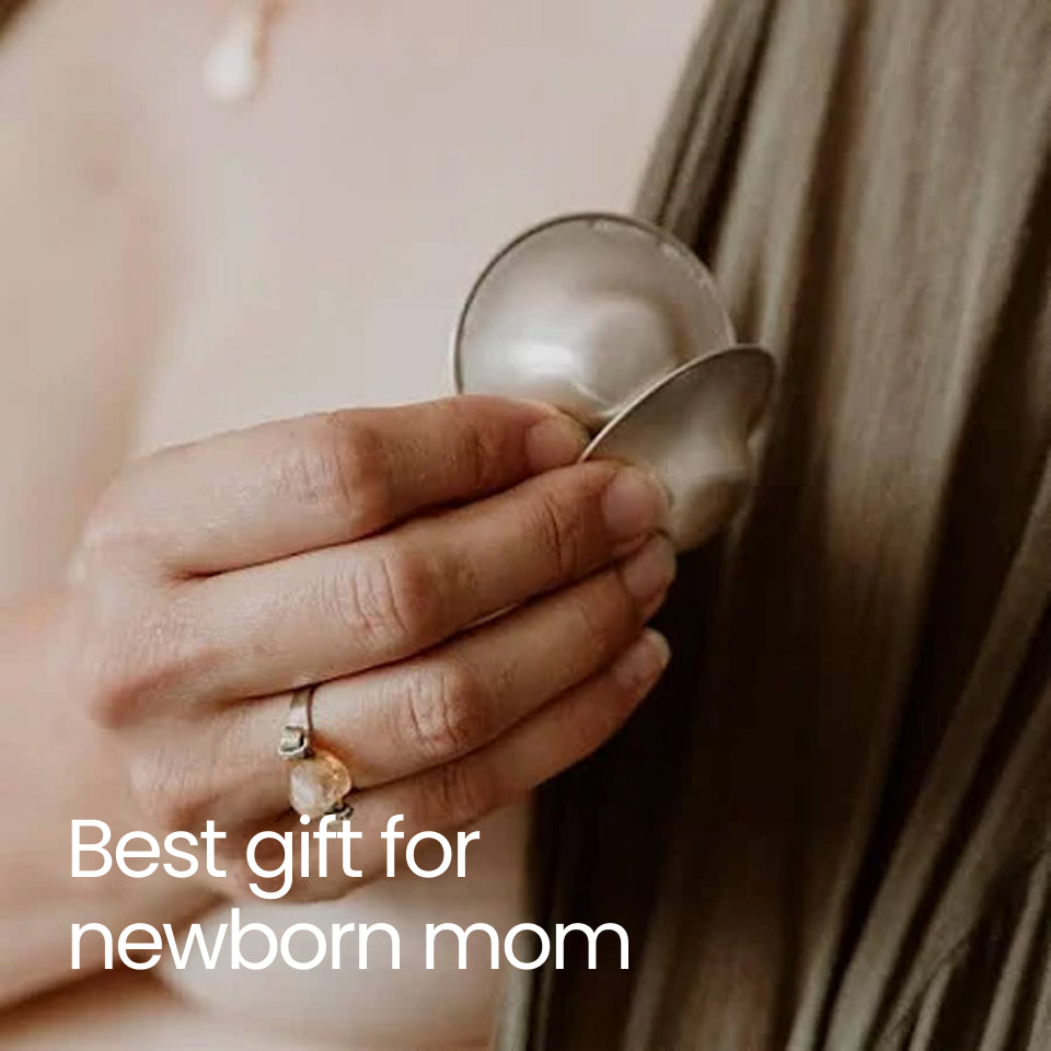 Close-up of a hand holding a solyymoms silver nipple shield which is the best gift for a newborn mom