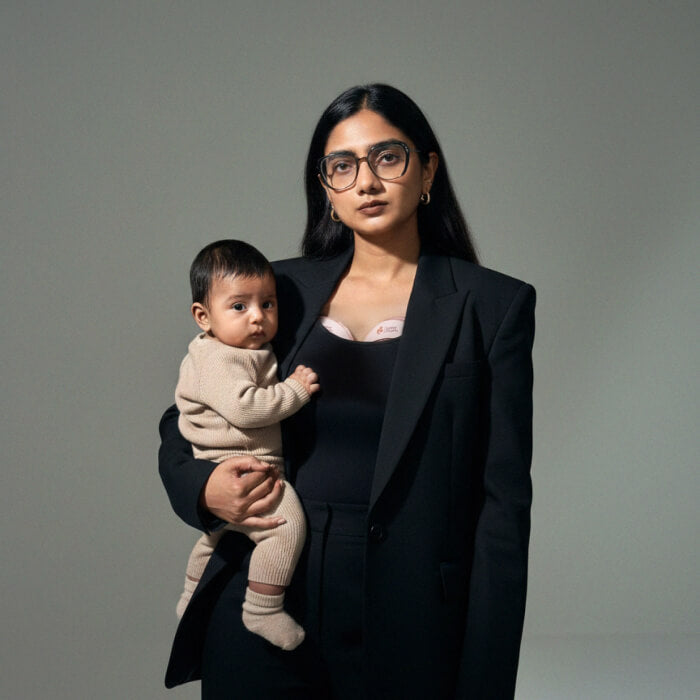 solyymoms founder standing with her baby held in her arms while using the solyymoms breast pump